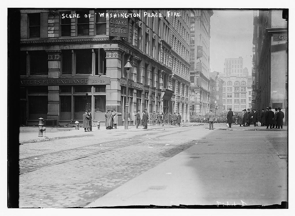 Street view of the tall Asch Building and a small group of people.