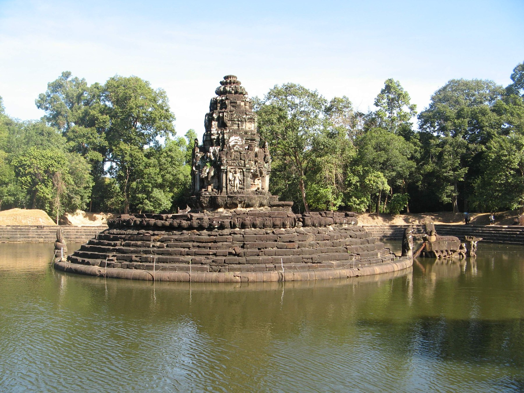 Circular stone sanctuary of Neak Pean within a rectangular water basin.