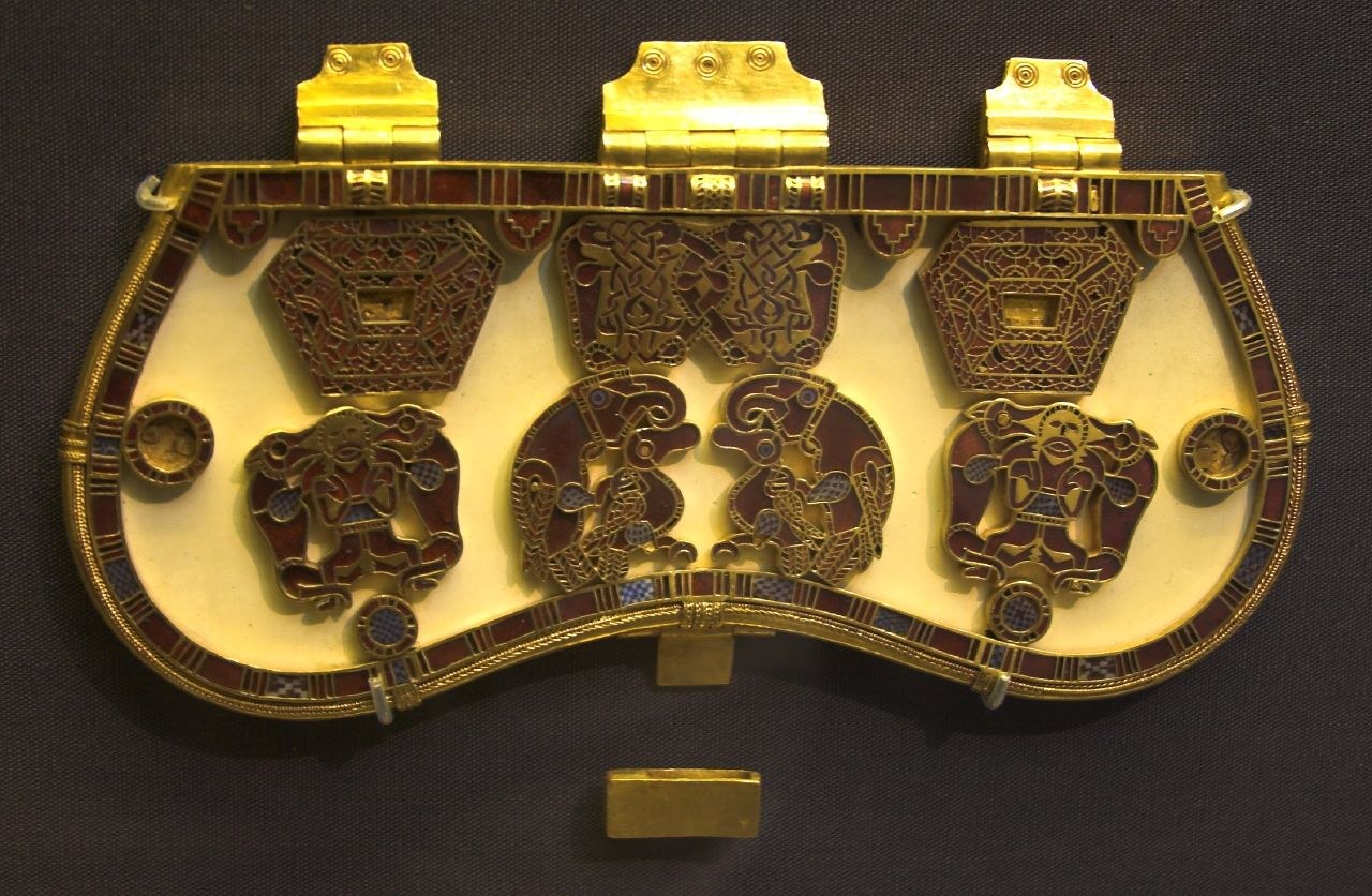 Sutton Hoo purse lid with gold frame and red garnet plaques arranged against a pale reconstructed backing.