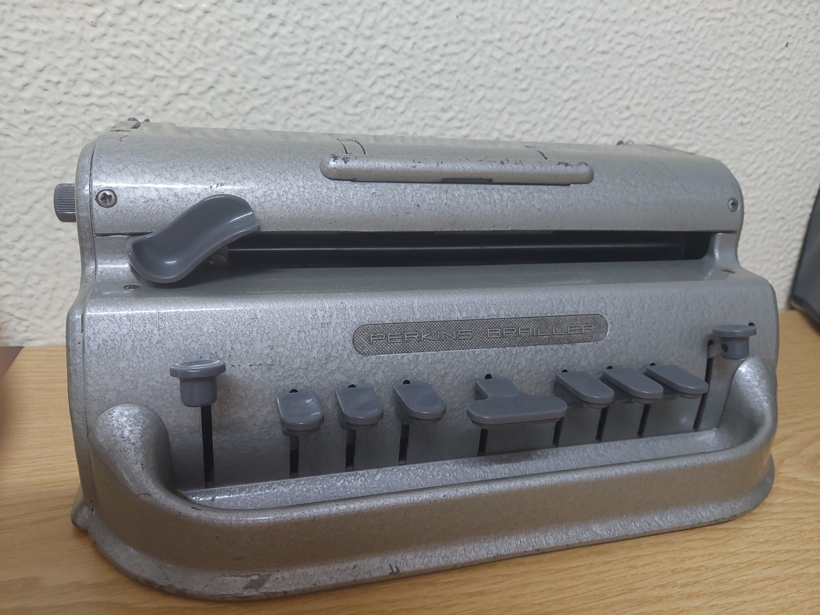 A mechanical Perkins Brailler with six main keys on a desk