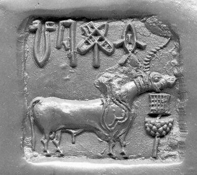 Black-and-white relief view of a buffalo and a device beneath a row of Indus signs.