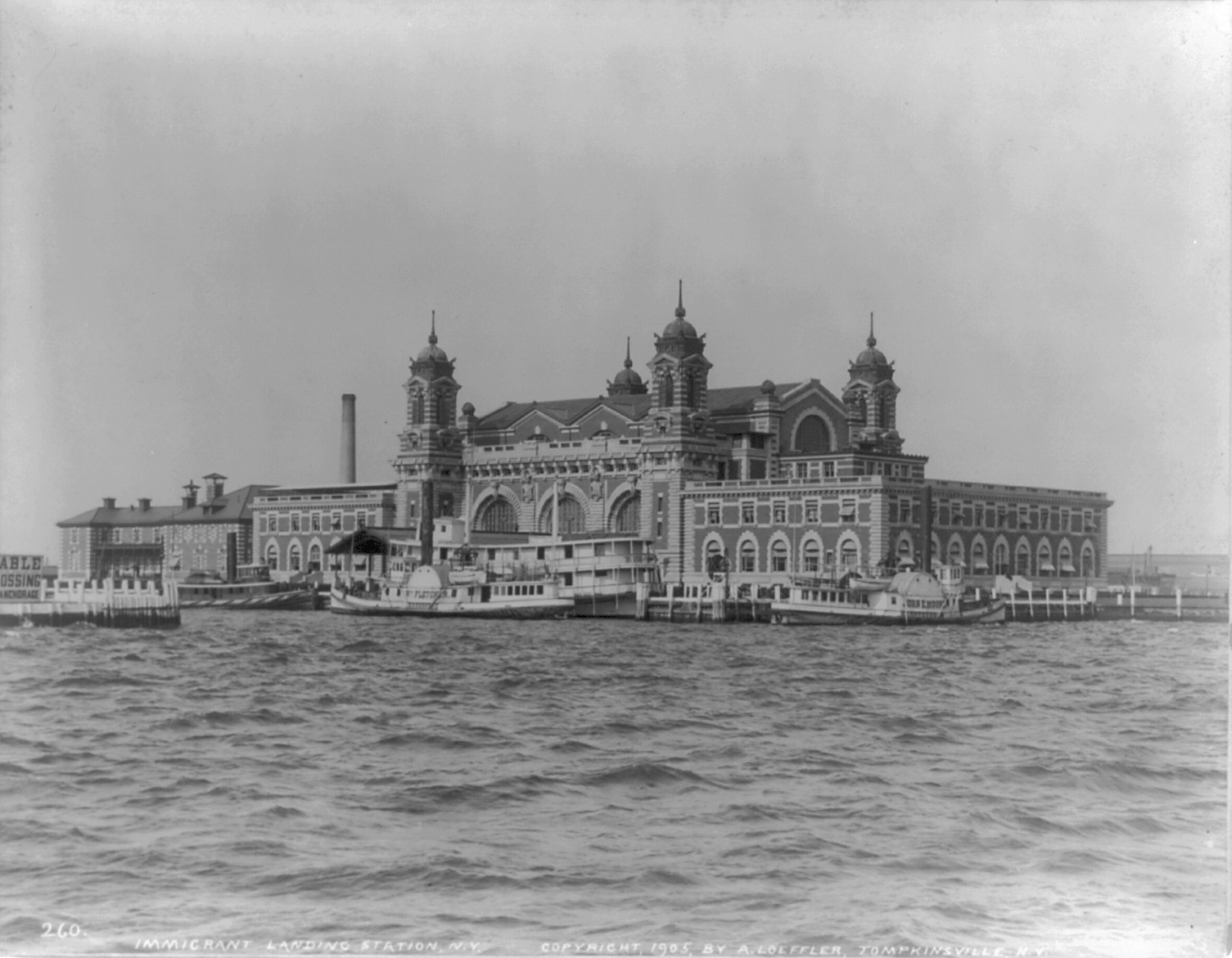 The Main Immigration Building viewed across the water in a black-and-white photograph.
