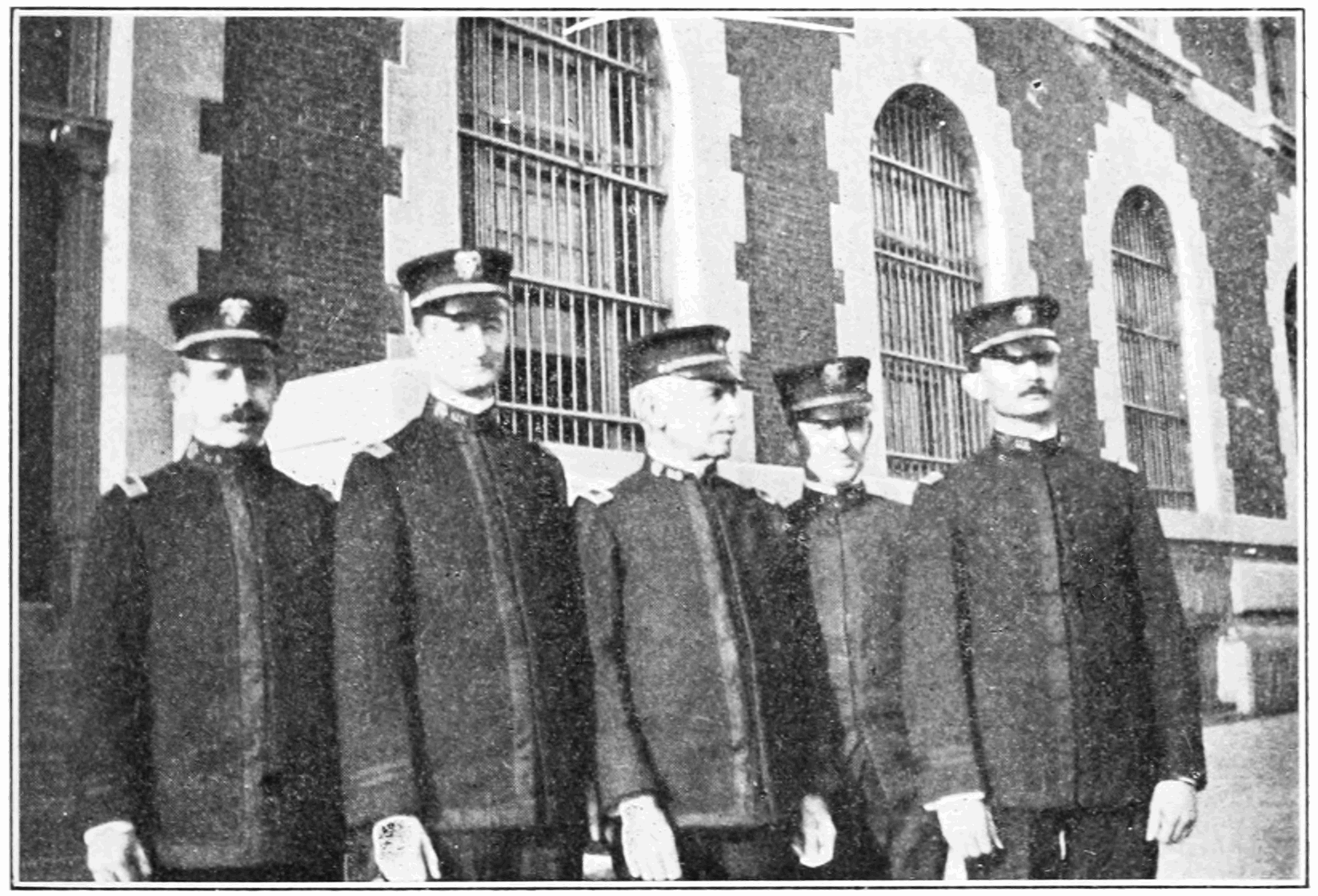 A row of uniformed medical officers standing outside an Ellis Island building.