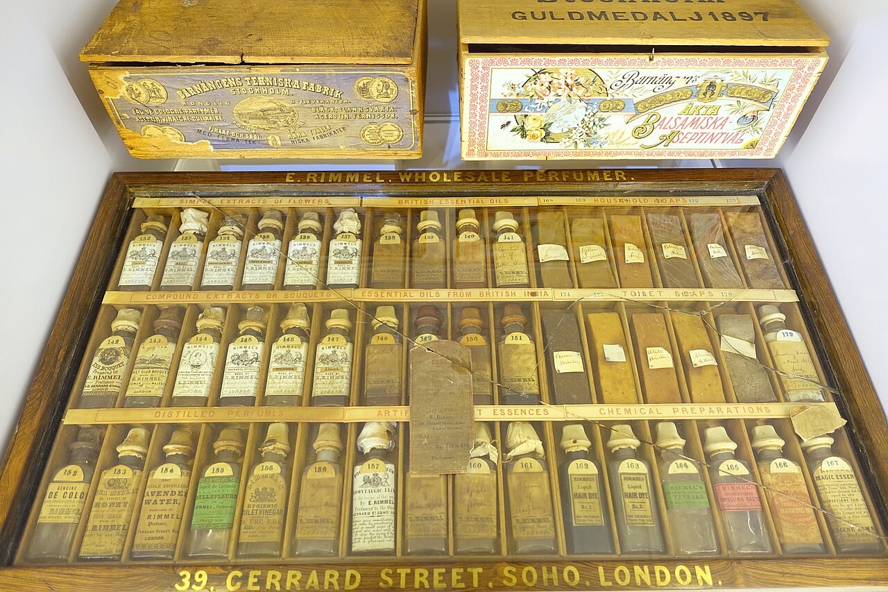 Collection of small labelled bottles of aromatic oils from India in a museum display
