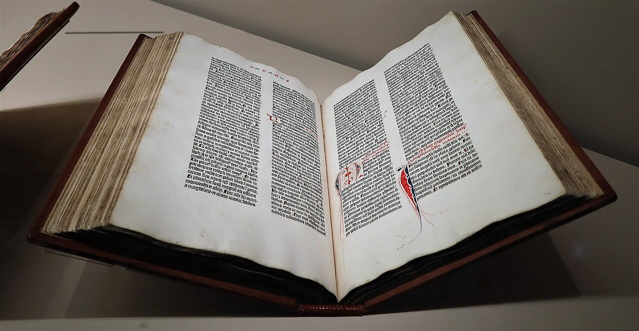 Open Gutenberg Bible with two columns of black text and colored decoration