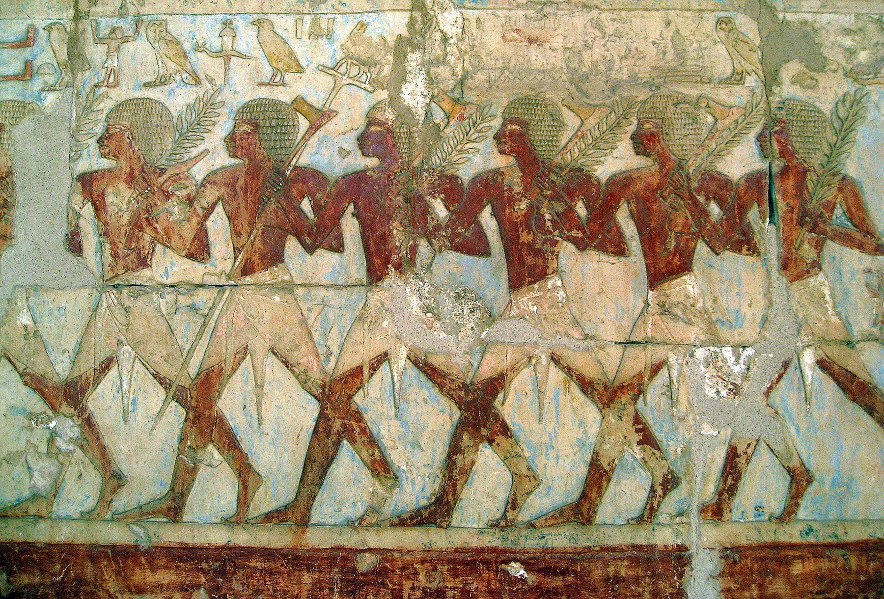 Carved Egyptian figures carrying branches and axes in the Punt expedition relief