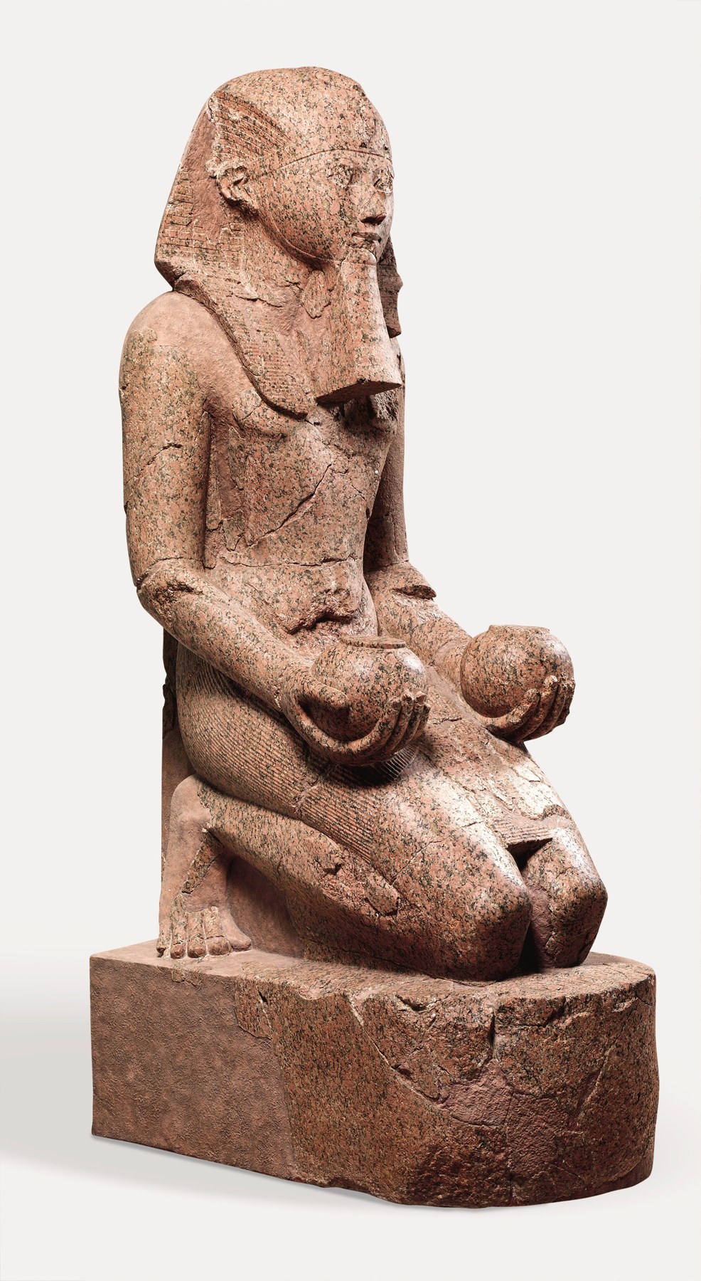 Restored kneeling stone statue of Hatshepsut holding offering vessels