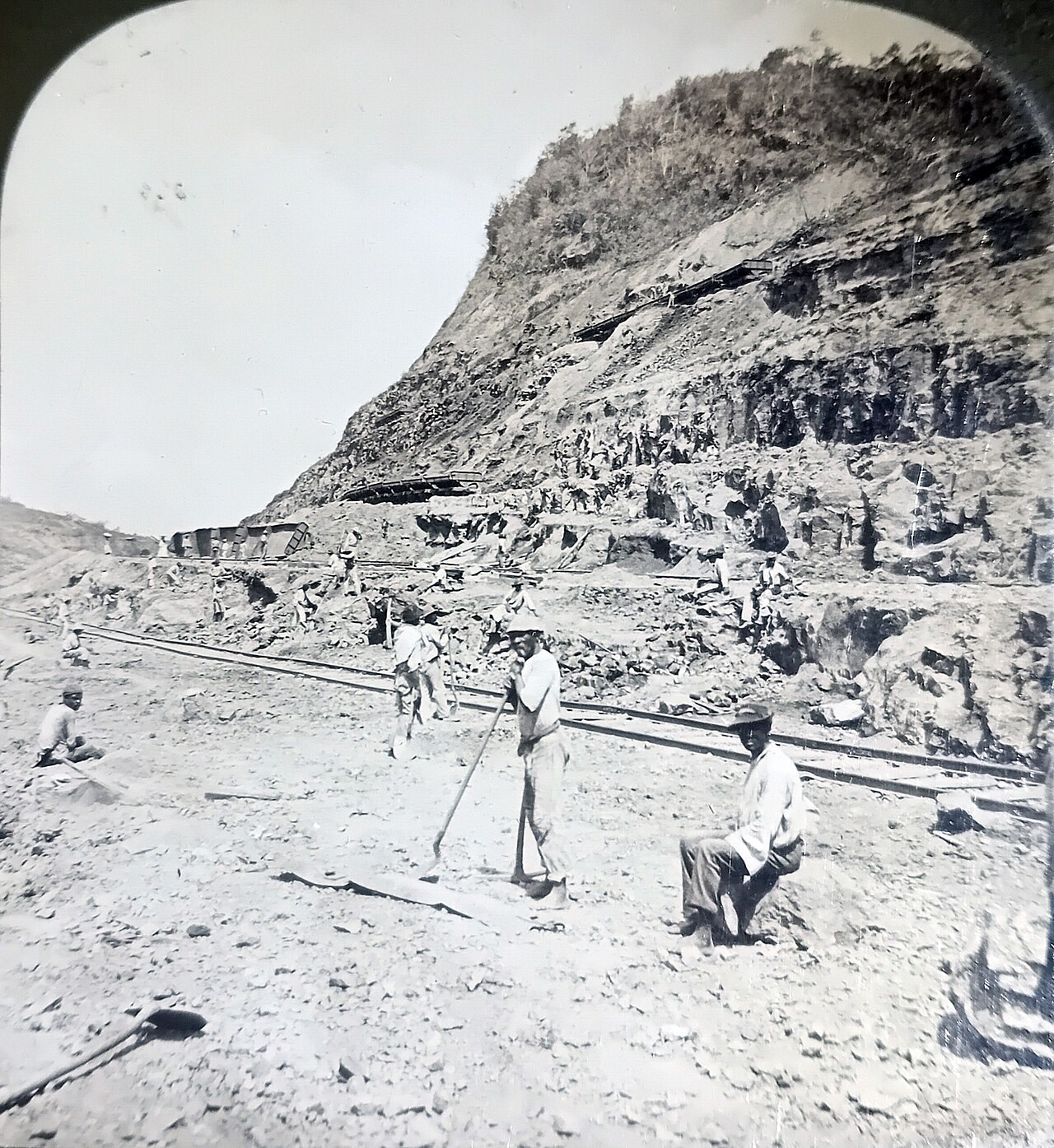 Workers standing among excavated earth and railway equipment at Culebra Cut