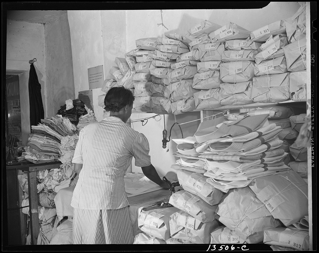 Workers among stacks of wrapped clothing in Johnnie Lew’s laundry in Washington, D.C.