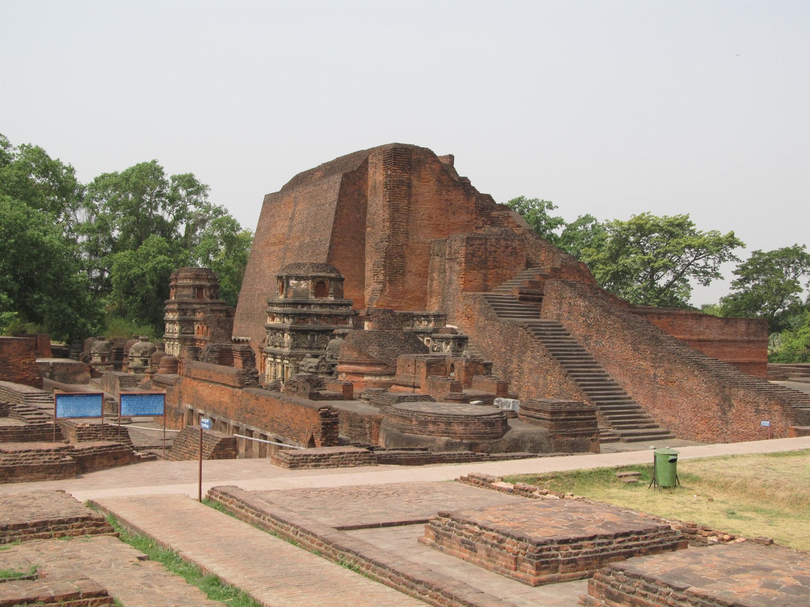 Red-brick temples and monastic remains at Nalanda beneath a pale sky.