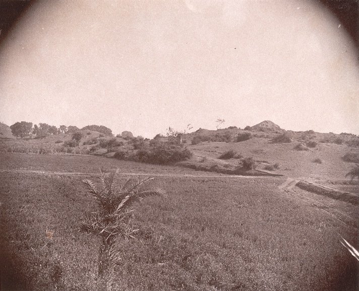 Historic black-and-white photograph of uneven ground and ruins in the Nalanda landscape.