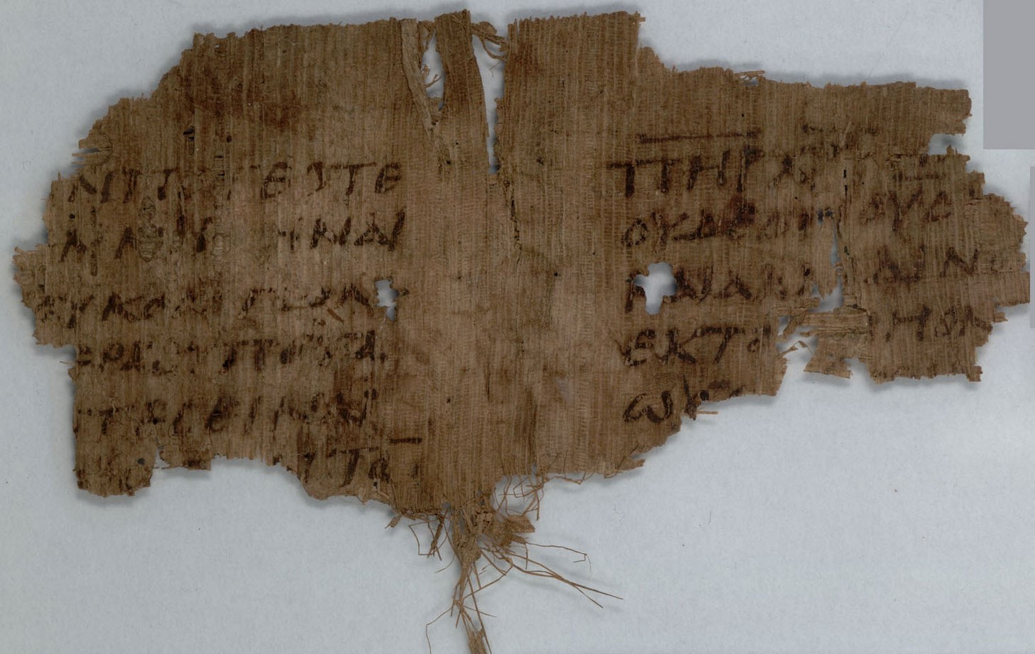 Fragment of brown papyrus with several incomplete lines of Greek handwriting, preserved against a pale background.