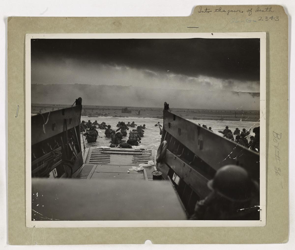 American soldiers leave a landing craft and wade toward Omaha Beach on D-Day.