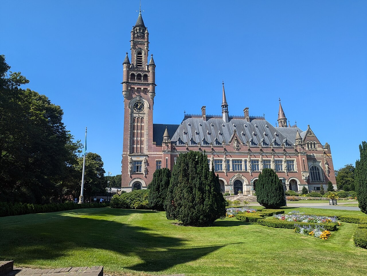 The red-brick Peace Palace in The Hague, with its tall clock tower and landscaped grounds.
