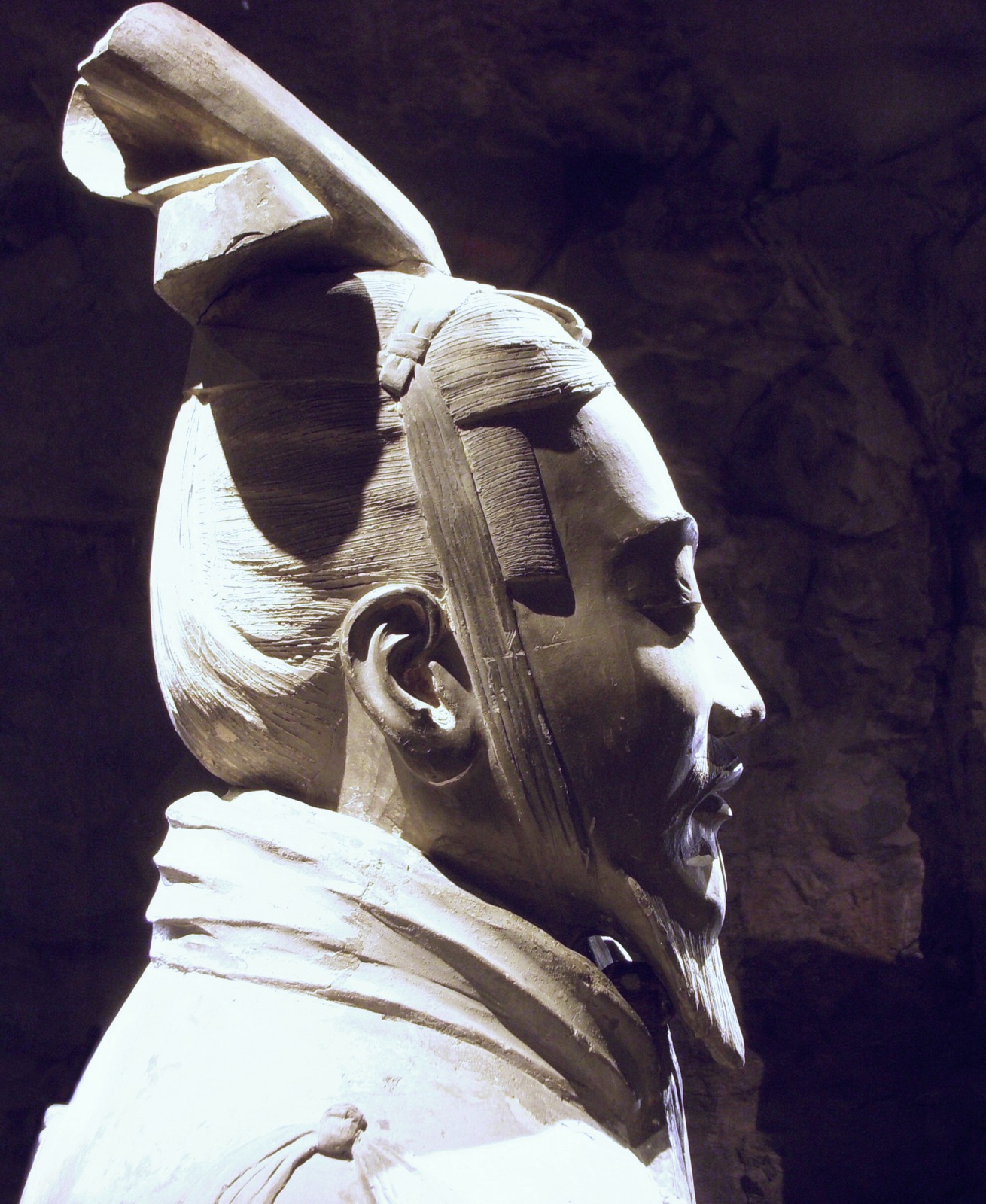 Close view of the head and shoulder of a terracotta general with elaborate headgear