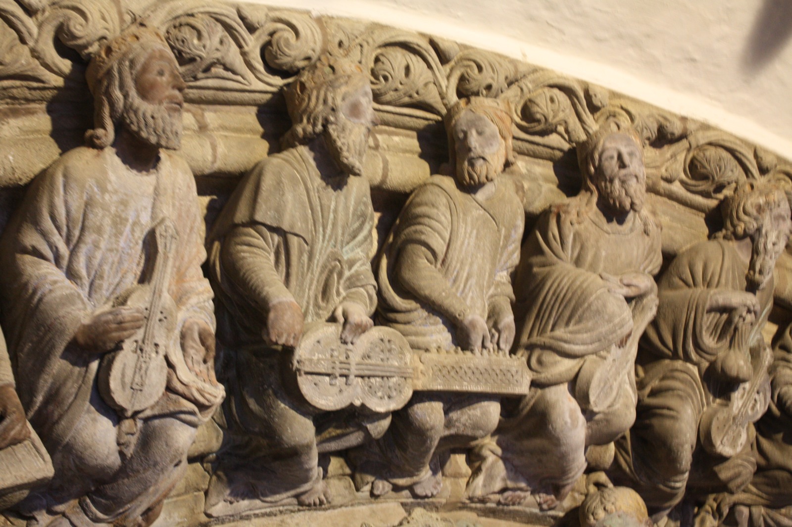 Carved seated elders with musical instruments on a cathedral arch